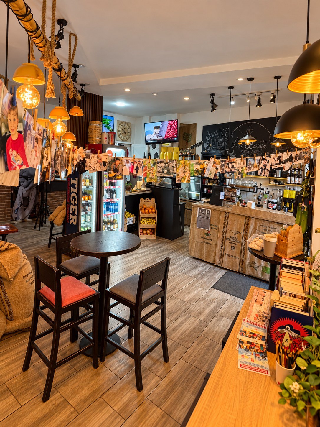 Interiorul La Barista, cu mesele de lemn, fotografii și barul cafenelei