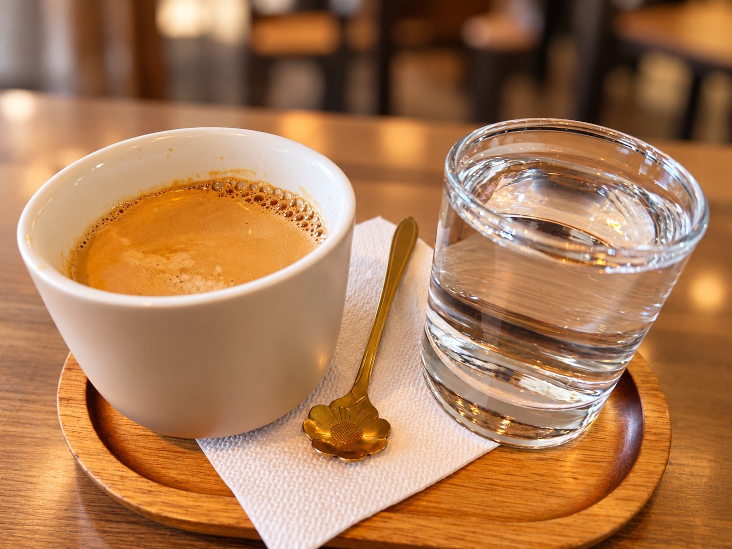 Long Black La Barista, cu pahar de apă și linguriță aurie