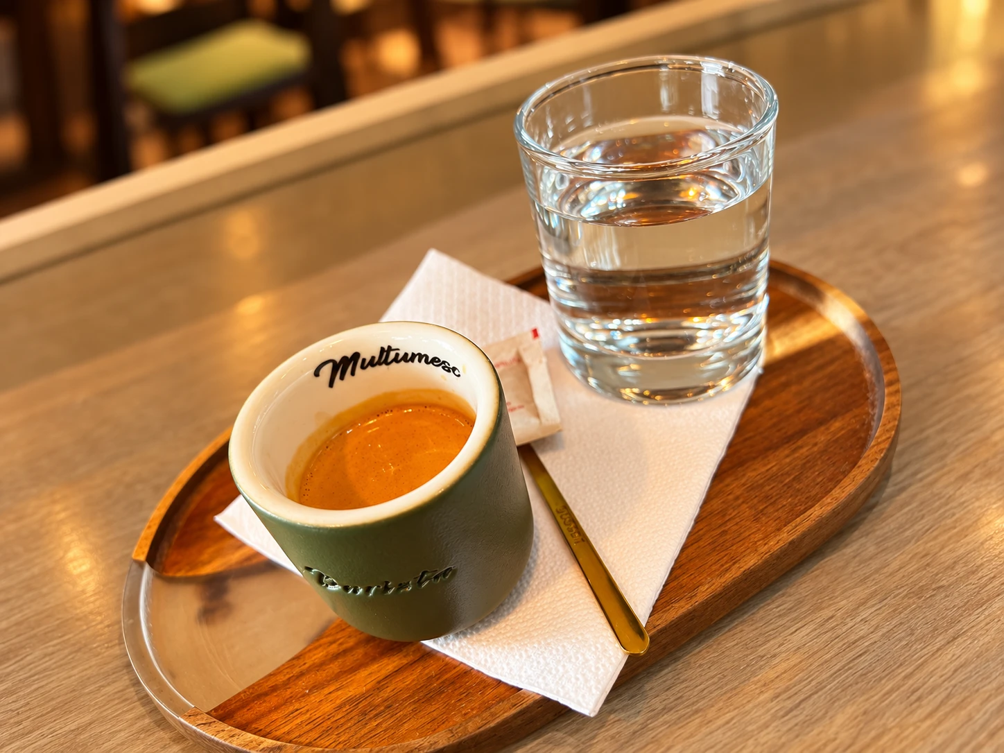 Espresso în ceașca verde La Barista, alături de un pahar cu apă