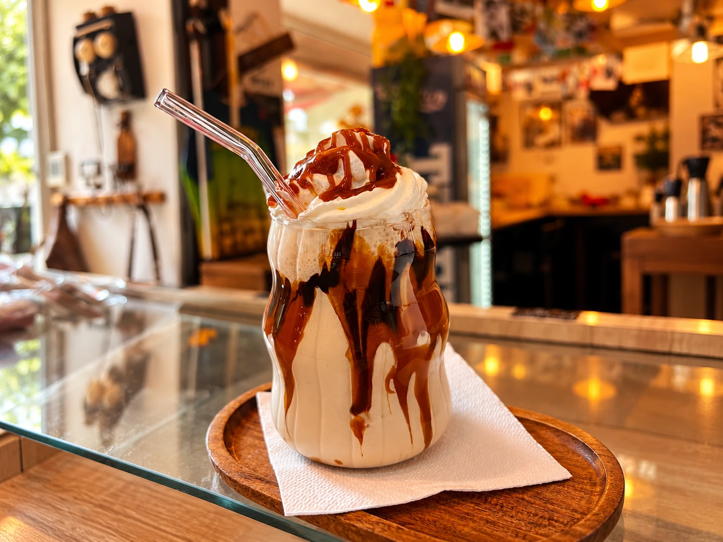 Frappe La Barista, cu frișcă și sirop, în pahar cu pai de sticlă