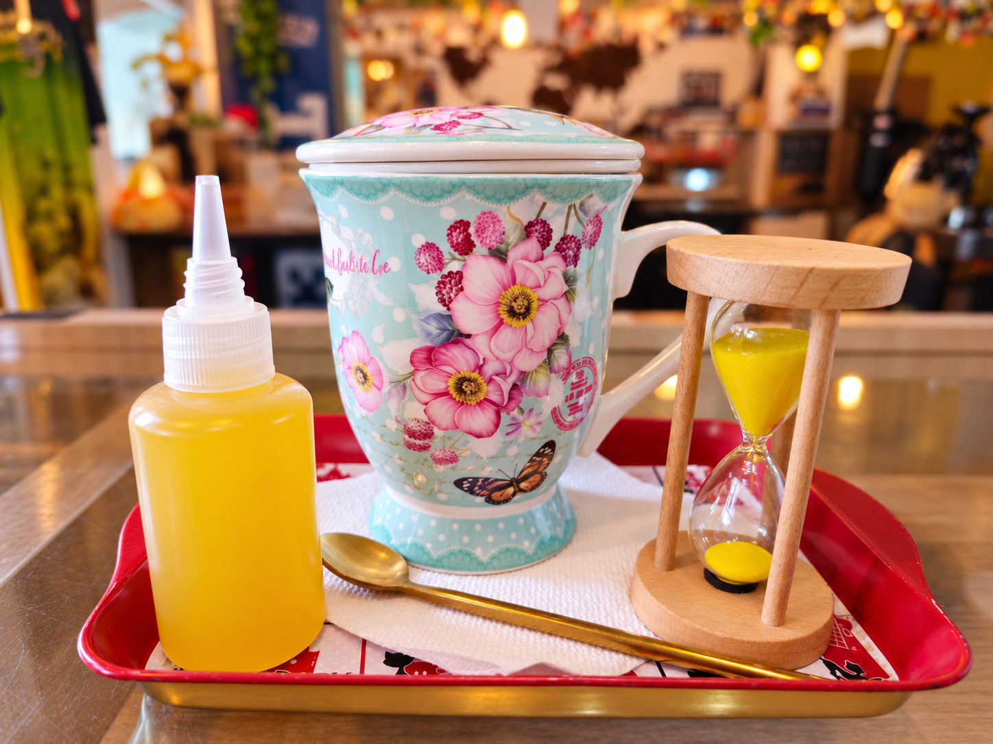 Ceai servit în cana florală La Barista, alături de clepsidră